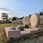 Monument funéraire avec galets hérisson et chat sculptés